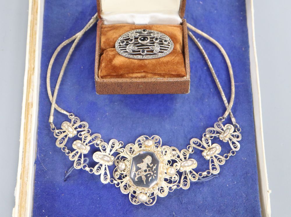 A Siamese filigree white metal and niello necklace and a marcasite brooch.